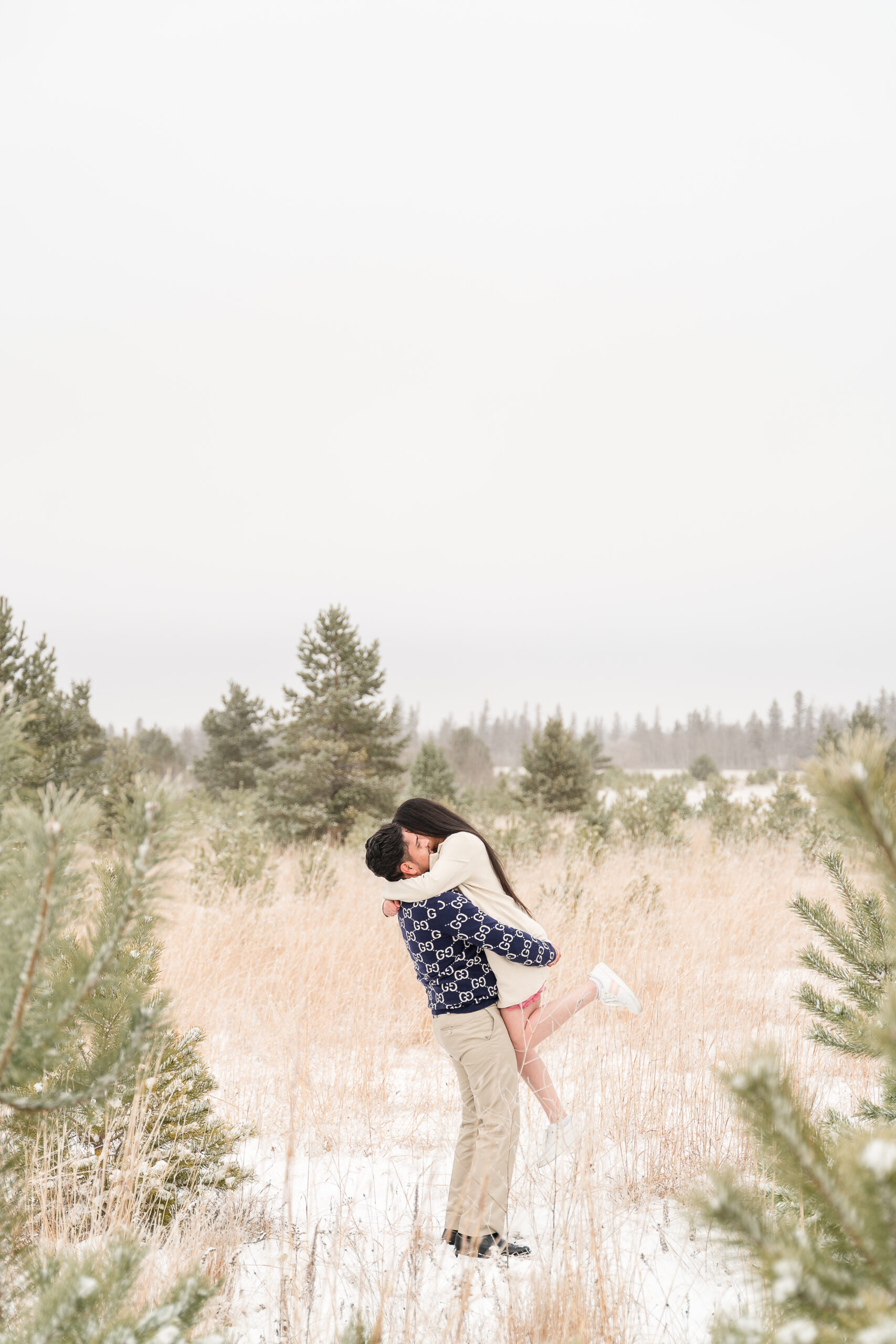 Couple twirling in Birds hill park during a photoshoot